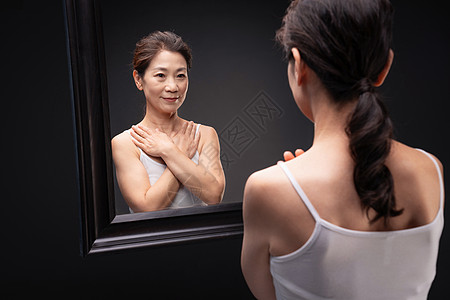 漂亮的中年女欣赏镜子中的自己图片