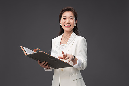 企业商务画册封面拿着户型图册的优雅商务女士背景