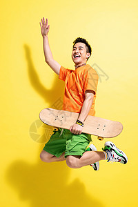 帅哥拿着滑板跳跃的青年男人图片