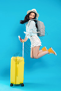扶着行李箱跳跃的年轻女孩背景图片