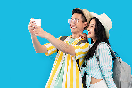 背景分离青年夫妇情侣旅途中快乐的青年伴侣用手机拍照图片