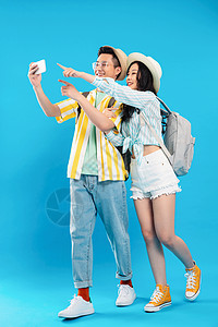 棚拍休闲背景分离旅途中快乐的青年伴侣用手机拍照图片