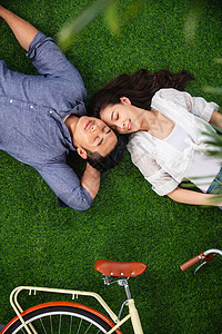 躺在草地上享受幸福时光的情侣图片