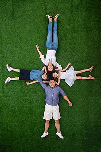 大头儿子小头爸爸青年人兄弟姐妹四个人幸福的一家四口头挨着头躺在草地上背景