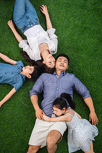 幸福一家幸福的一家四口躺在草地上休息背景