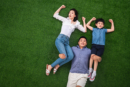 假日白昼双亲家庭在草地上强壮的青年男人驮着妻子和儿子图片