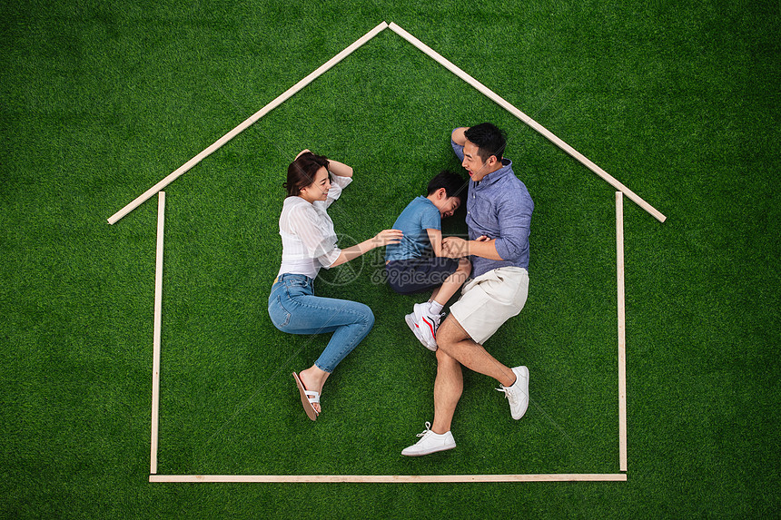 减压独生子女家庭亲情快乐的一家三口躺在草地上的房子轮廓里玩耍图片