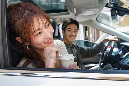 女朋友驾驶都市风光青年伴侣坐在汽车里喝饮料图片