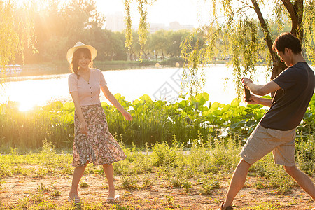 健康女性女朋友户外男朋友幸福情侣在公园里拍照背景