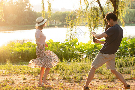 荷叶上的情侣手机25岁到29岁季节幸福情侣在公园里拍照背景