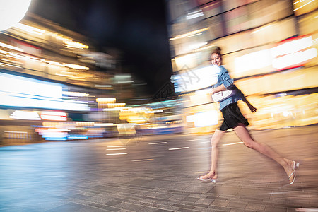 水平构图街道夜晚行走的路上的青年女人图片