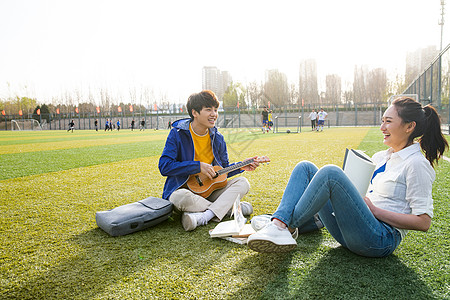 青年大学生在校园里弹奏吉他高清图片