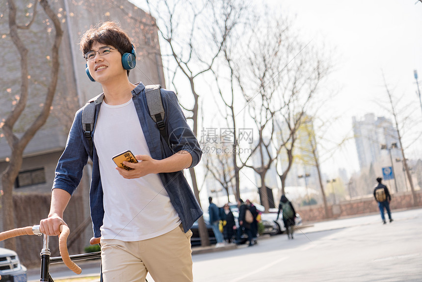 青年文化大学生在校园里骑自行车图片