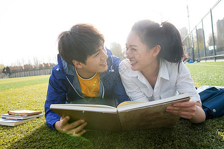 草地大学生情侣在校园里学习图片