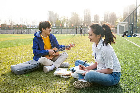 青年大学生在校园里弹奏吉他图片