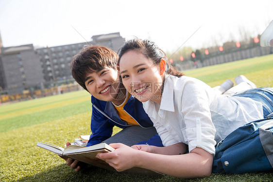 高兴的看书休闲活动大学生情侣在校园里学习图片