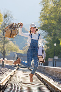 美女青年人徒步旅行青年女人在铁轨上跳跃图片