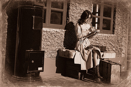 青年女人坐在火车站站台上看书图片