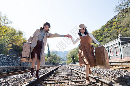 青年闺蜜手牵手走在铁轨上图片