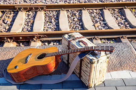 传统文化乐器非都市风光铁轨旁边的吉他和旅行箱高清图片