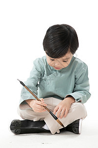 节日传统服装嬉戏的可爱的小男孩坐在地上用毛笔写字图片