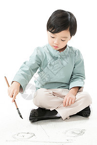 彩色图片天真有趣的可爱的小男孩坐在地上用毛笔写字图片