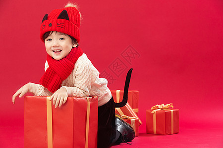 活力围巾拜年可爱的小男孩趴在新年礼物上玩耍图片