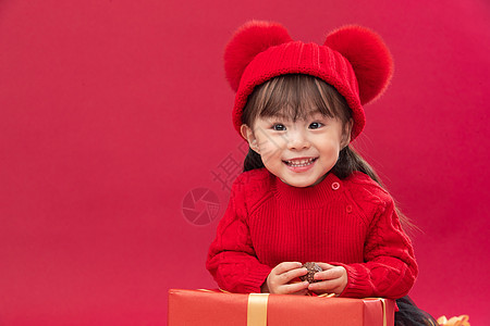 祝福休闲装拜年可爱的小女孩趴在新年礼物上图片