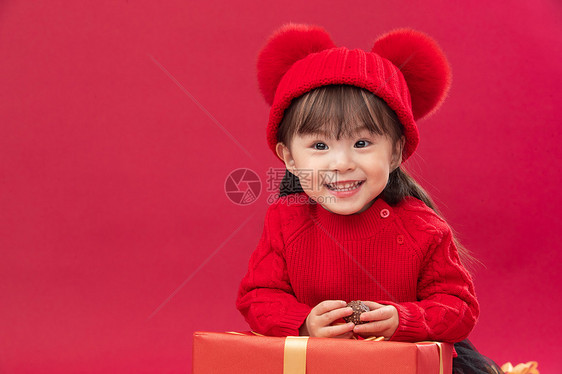 祝福休闲装拜年可爱的小女孩趴在新年礼物上图片