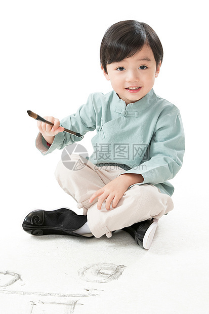 唐装学习嬉戏的可爱的小男孩坐在地上用毛笔写字图片