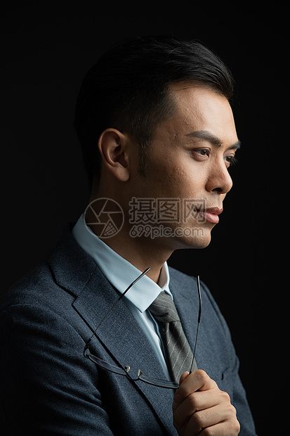 拿着眼镜思考的商务男士图片