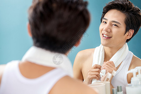 个人护理化妆品表现积极快乐的年轻男人拿着毛巾照镜子图片