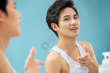 年轻活力学生照镜子青年男人自信的年轻男人对着镜子做手势背景