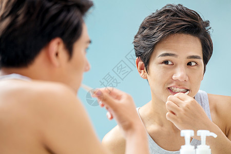 牙刷无忧无虑成年人年轻男人对着镜子在刷牙图片