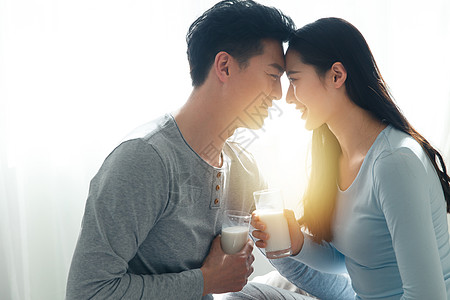 面对面亲密青年情侣喝牛奶背景图片
