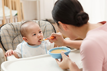 孩子趴在粥碗上妈妈喂宝宝吃饭背景