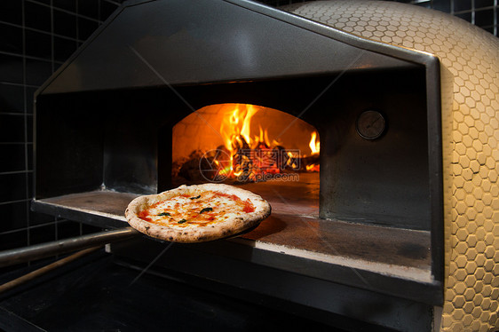 无人烤炉烹饪餐厅里烤制披萨图片