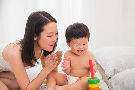 活力女性婴儿用品床坐着妈妈陪宝宝玩耍背景