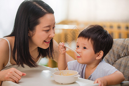 和妈妈一起吃饭居家年轻妈妈喂宝宝吃饭背景