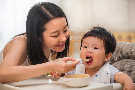 和妈妈一起吃饭居家年轻妈妈喂宝宝吃饭背景