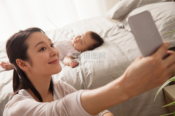 年轻妈妈给宝宝拍照图片