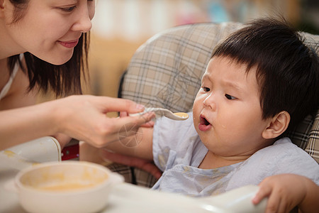 儿子母子快乐幸福妈妈喂宝宝吃饭背景