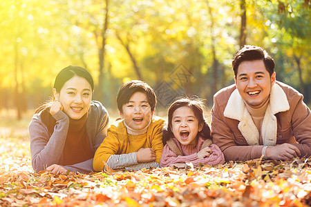 幸福家庭趴在草地上季节高清图片素材