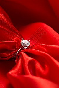 夺目订婚钻戒绸缎摄影情人节红丝绸和钻石戒指背景