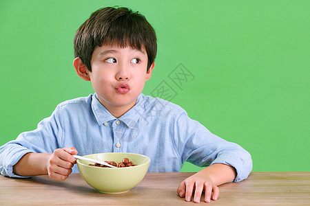 绿色背景有趣的快乐小男孩吃东西图片