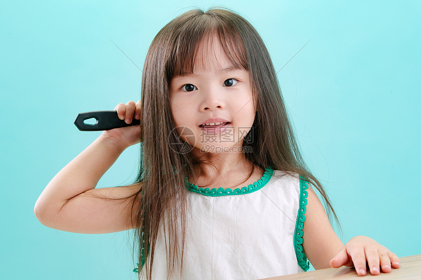 微笑水平构图东亚可爱的小女孩梳头发图片
