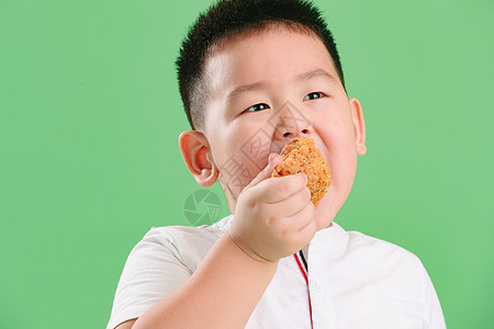 快乐油炸食品饥饿的可爱的小男孩吃炸鸡图片