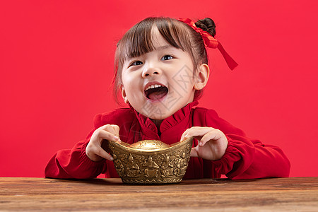 单纯好奇心天真小女孩拿着金元宝过新年背景图片