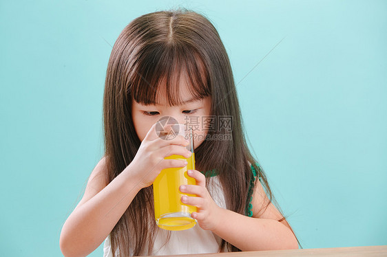 摄影肖像好奇心可爱的小女孩喝饮料图片