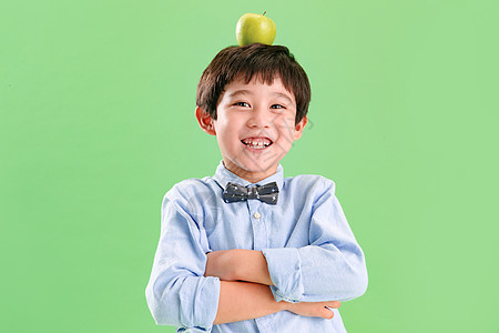 可爱小男孩头上顶着一个苹果图片